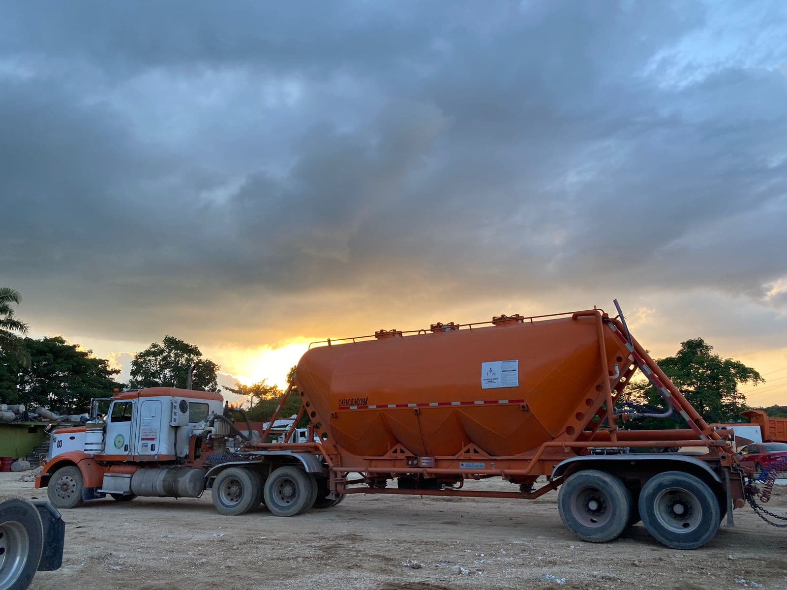 Tolva presurizada naranja de Transportes Brito al atardecer